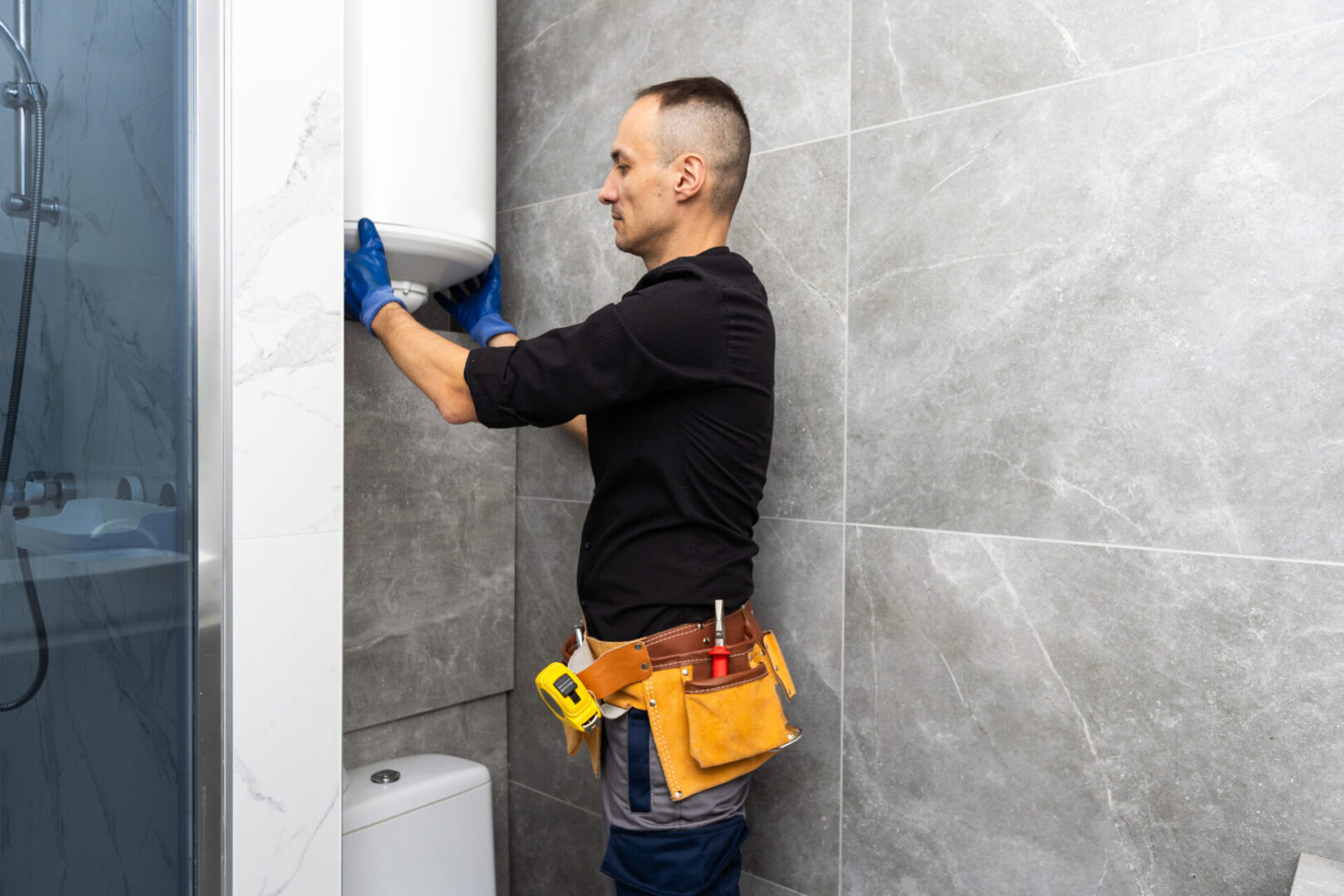 Male plumber repairing boiler in bathroom. High quality photo